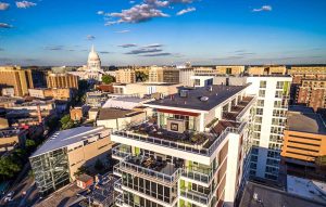 A drone view of the Ovation 309 building and the Madison, WI state capitol building