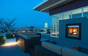 A view of a balcony with gas fireplace and the Madison, WI state capitol building