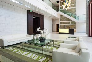 A common area in an apartment building with couches and a glass table