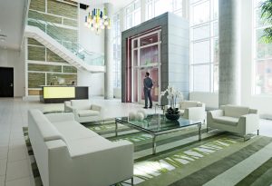 The main entrance to Ovation 309 with a Concierge at the door, a man at the welcome desk, and couches and tables