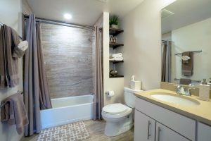 A bathroom with a tub, toilet, and sink with built-in cabinets