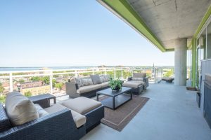 A view of an apartment balcony with couches and chairs